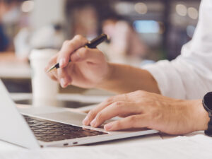 Person using a laptop to research the benefits of local SEO at their desk.