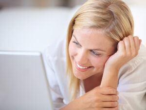 She looks up how to convert a blog reader to a customer via her laptop.
