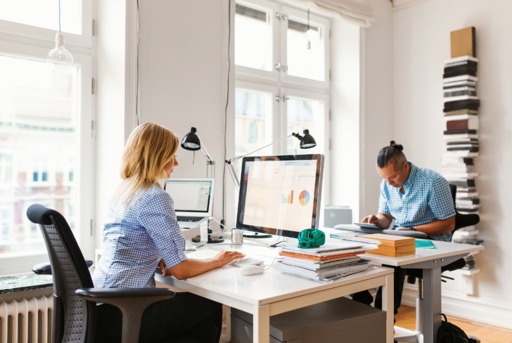 Two people working at computers to build their small business marketing plan