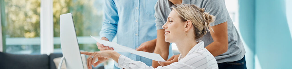 They discuss content marketing cost while looking at data via computer.