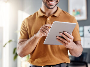 A man smiles while exploring diy digital marketing on his tablet.