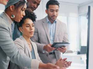 Small business owners discuss hiring a marketing agency while collaborating at a computer.