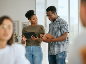 Two people discuss tips for local SEO as they look at data on a tablet