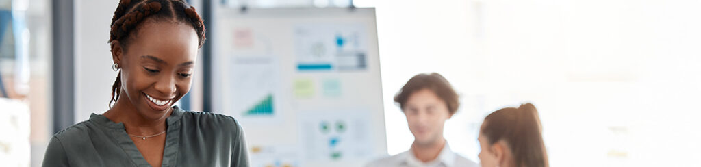 Colleagues in a meeting searching up and reviewing data on a whiteboard comparing SEO vs Google Ads.