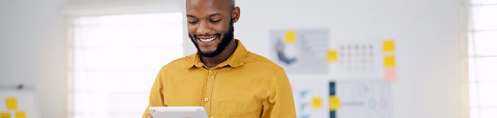 Male small business owner uses a tablet to list his business on Google Maps.