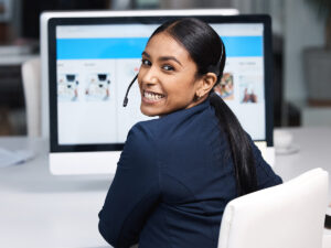 Woman wearing a headset while making a website for business at her desk