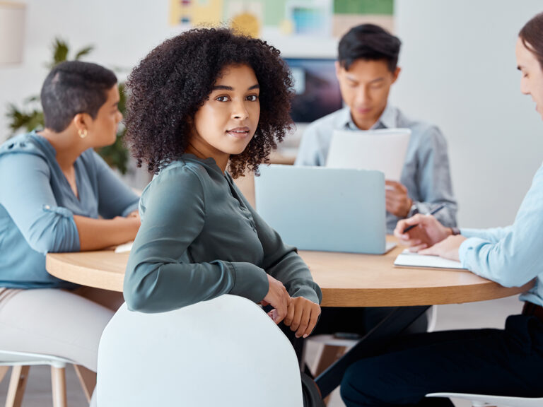 Small business colleagues discuss finding competitors' keywords in a small meeting