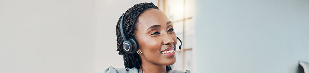 She smiles while working on seo copy in front of a screen