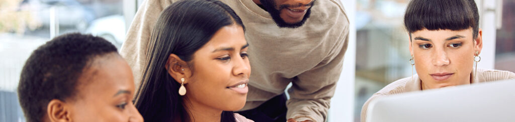 They look at a computer screen while one explains why invest in local SEO services to the group.