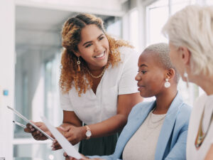 Three women discuss content to generate leads in a bright setting.