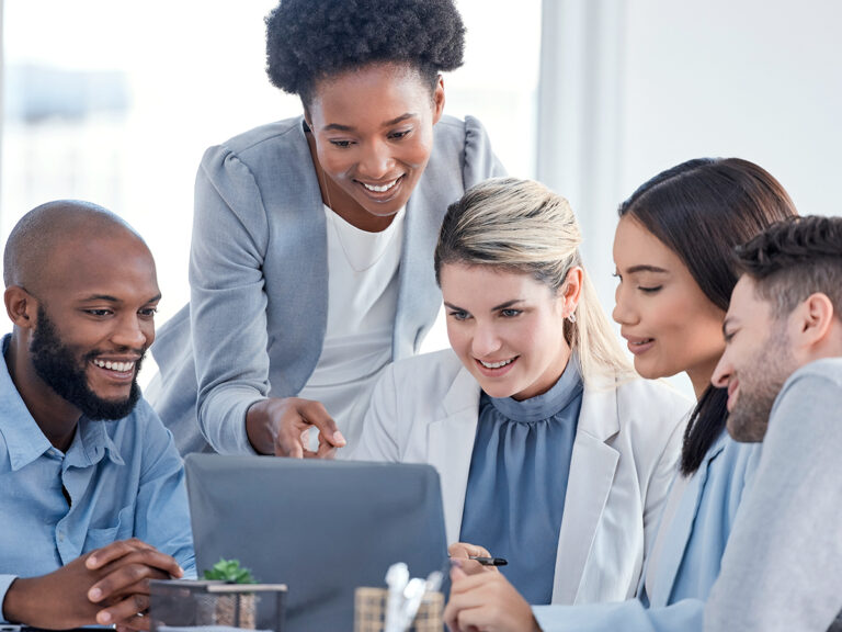 Five people gather around a laptop, discussing strategies with a marketing integrator during a meeting.