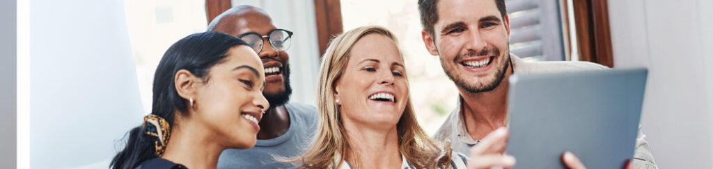 Four people in a small business team looking at a tablet together and discussing the business' positive Google reviews.