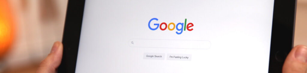 A tablet displays the Google homepage with the search bar and two buttons visible.