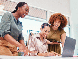 three employees discussing backlink strategy while reviewing a website on a laptop in an office