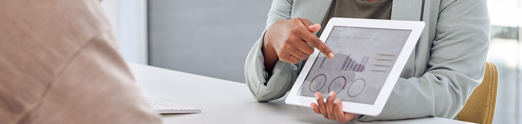 Person pointing at a tablet displaying SEO and click through rate graphs while discussing.