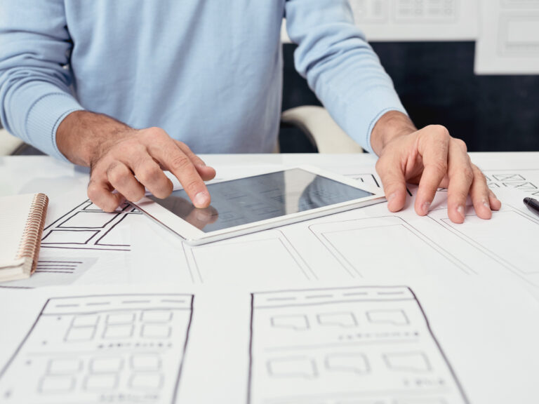 man drawing a plan on his ipad as he works to create a small business website for his company