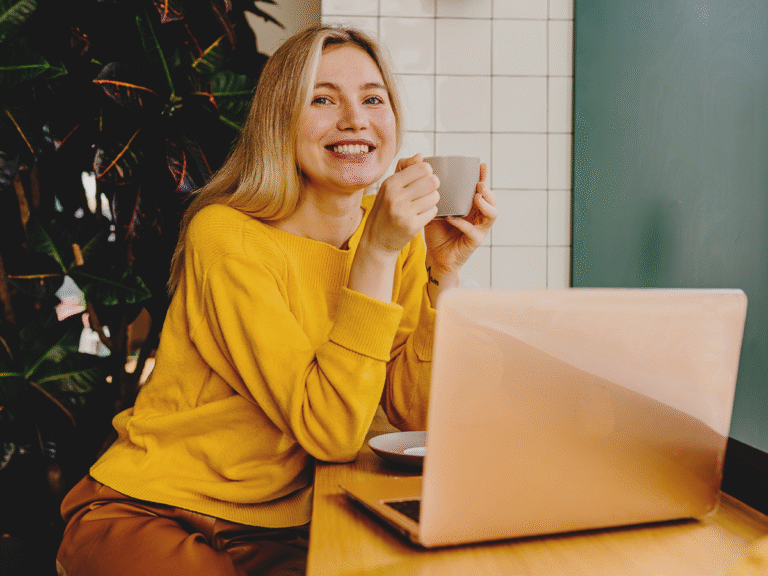 Businesswoman smiling while working on her laptop, building local backlinks to improve online visibility.