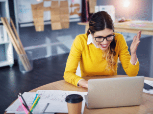 Woman smiling with her laptop and sketchpad, working on her service area page strategy for local SEO growth.