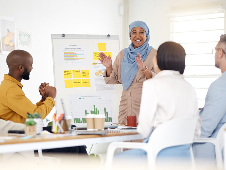 A woman discussing plans for a blog strategy to colleagues in a meeting room