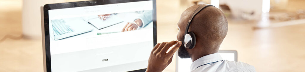 evergreen content Man wearing headphones viewing monitor with notebook and laptop image explaining evergreen content strategy.