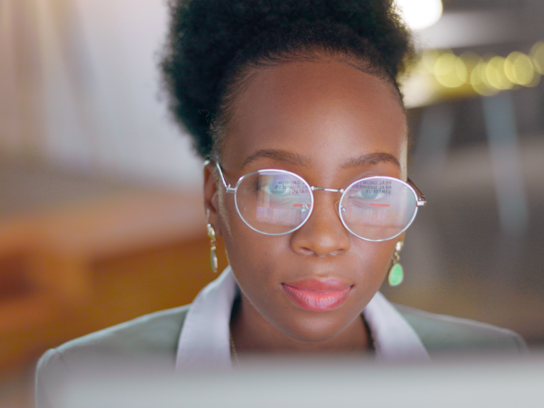 Woman with glasses viewing monitor showing local keyword research for SEO strategy and business growth.